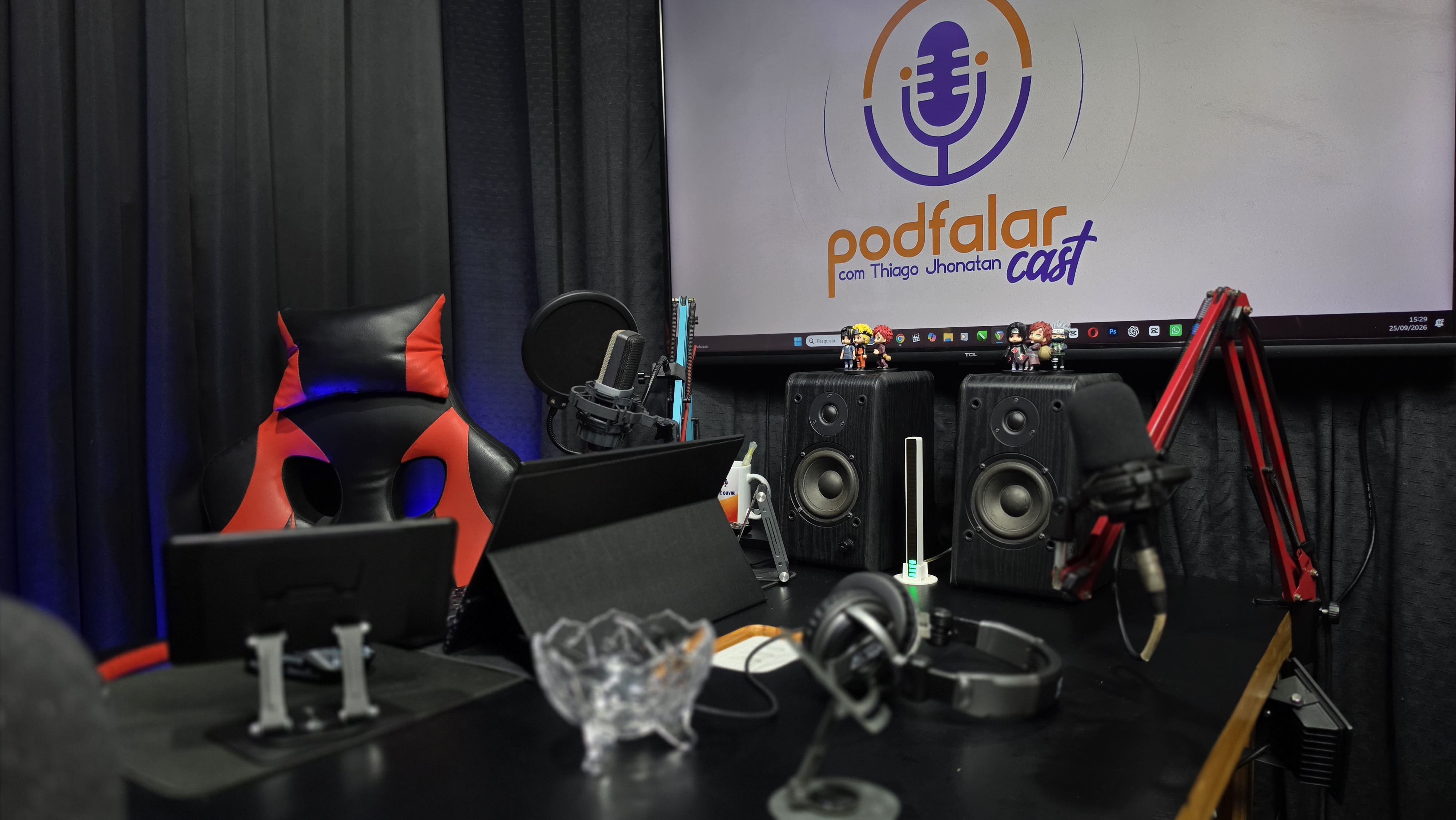 Visão geral do estúdio, com a bancada, microfones e equipamentos de produção
